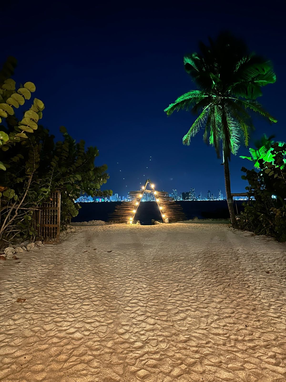 Entrada de Namasté Beach de noche con vista al skyline de Cartagena